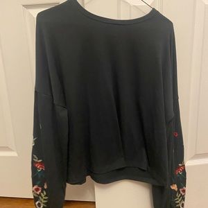 Black long sleeved shirt with floral patching on the sleeves